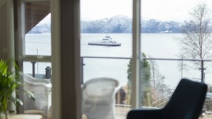 A view from a room with a large window overlooking a body of water and mountains. - Lavik Fjord Hotell (Hoyanger)