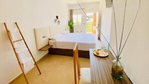 A bedroom with a bed, a bedside table with a glass vase, a chair, and a ladder against the wall. - Hotel Playa Terreros by Blossom Hotels (Pulpi)