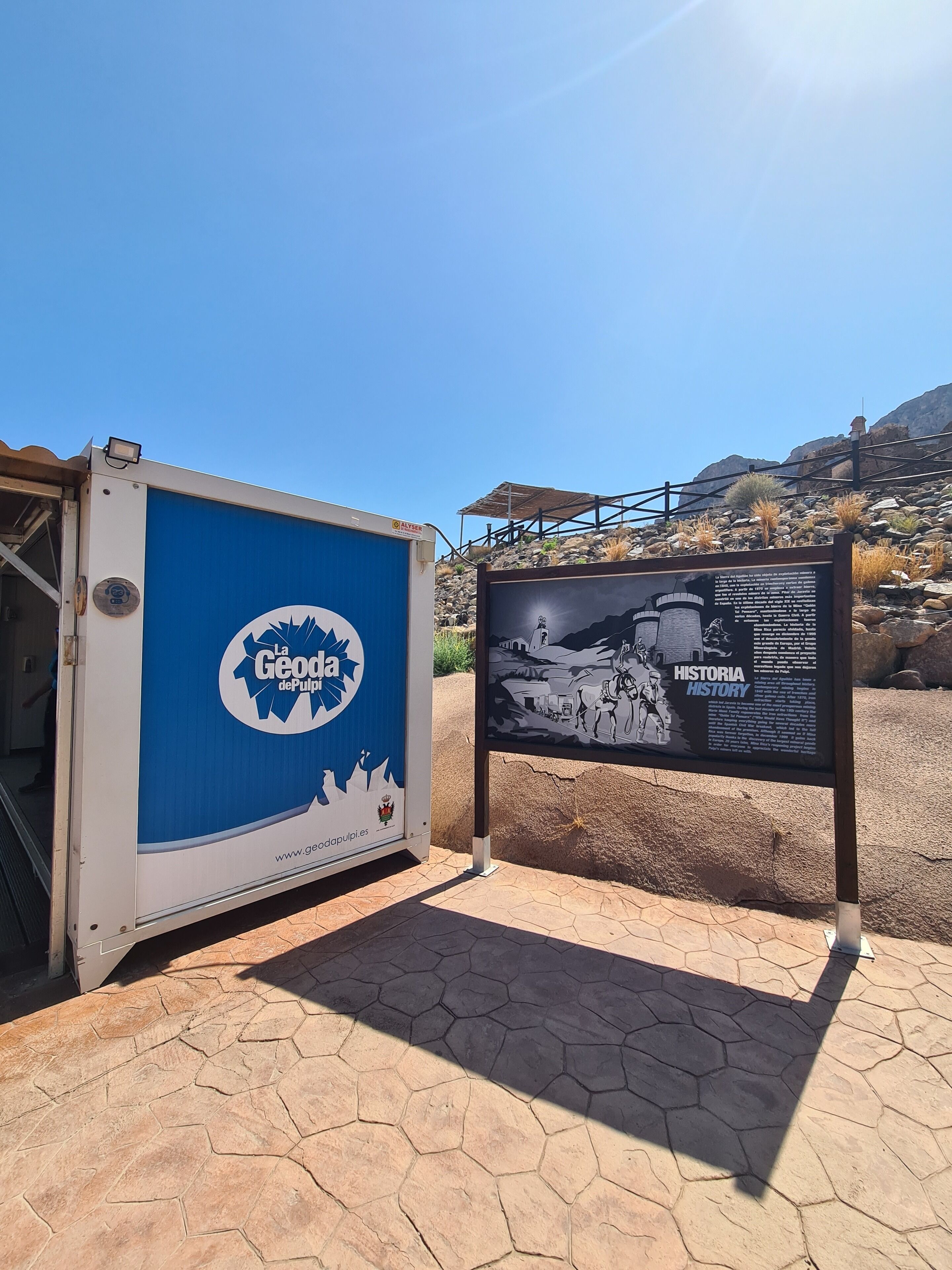 A blue and white structure with a signboard next to it.