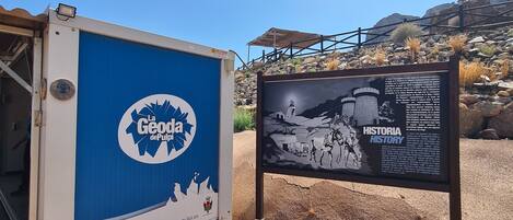 A blue and white structure with a signboard next to it.