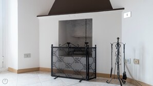 A room with a white wall, a black metal gate, and a broom on a stand. - Italianway   - Bligny 39 (Milan)