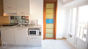 A modern kitchen with white cabinets, a microwave, and a coffee maker. - Italianway   - Bligny 39 (Milan)