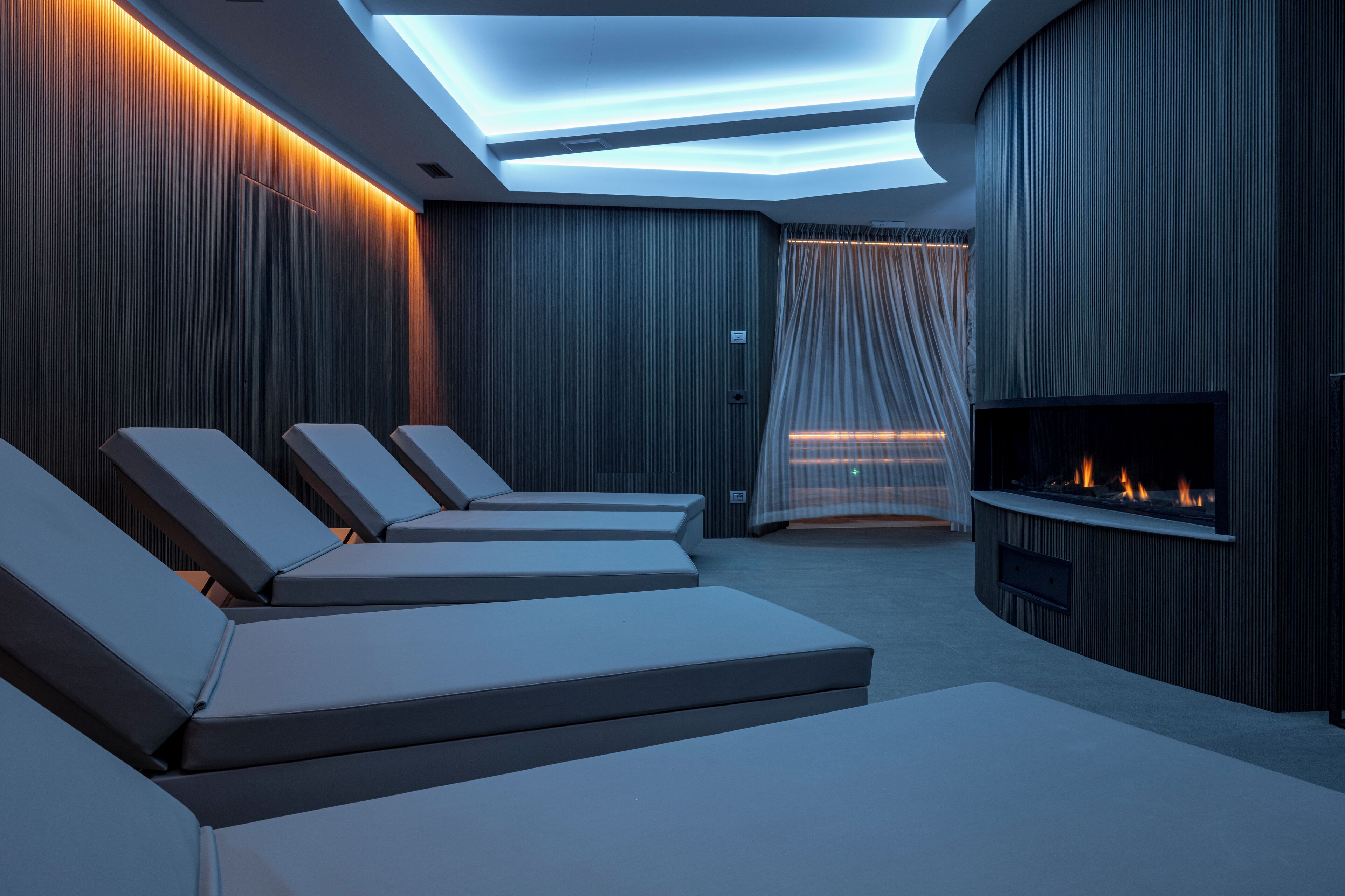 Un espace de détente moderne, doté de fauteuils confortables, d’une cheminée et d’une verrière.