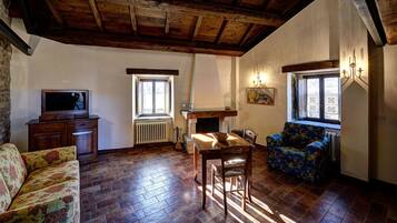 Ein gemütliches Wohnzimmer mit Kamin, Holzmöbeln und einem Fernseher.