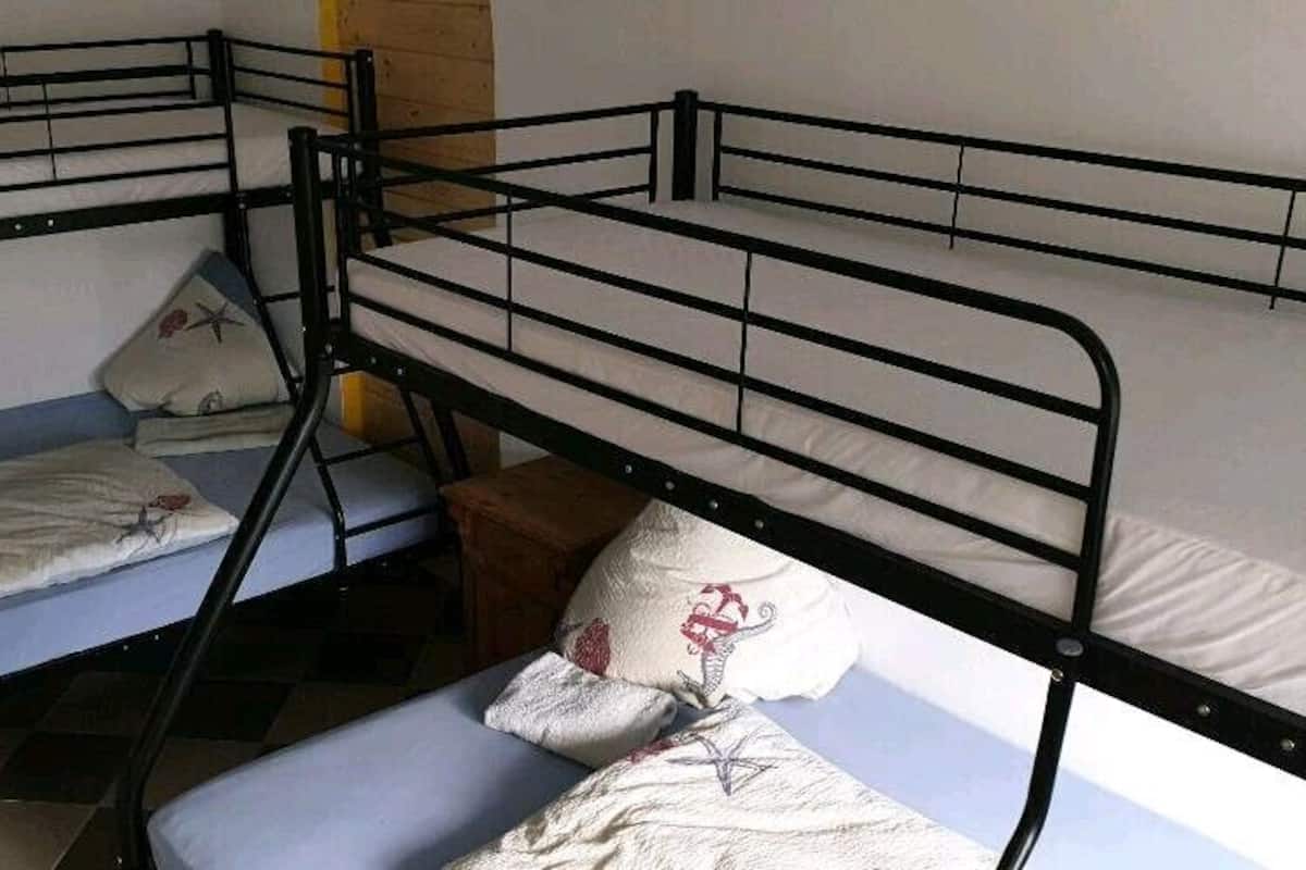 Um dormitório com três beliches, cada um com travesseiro e cobertor.