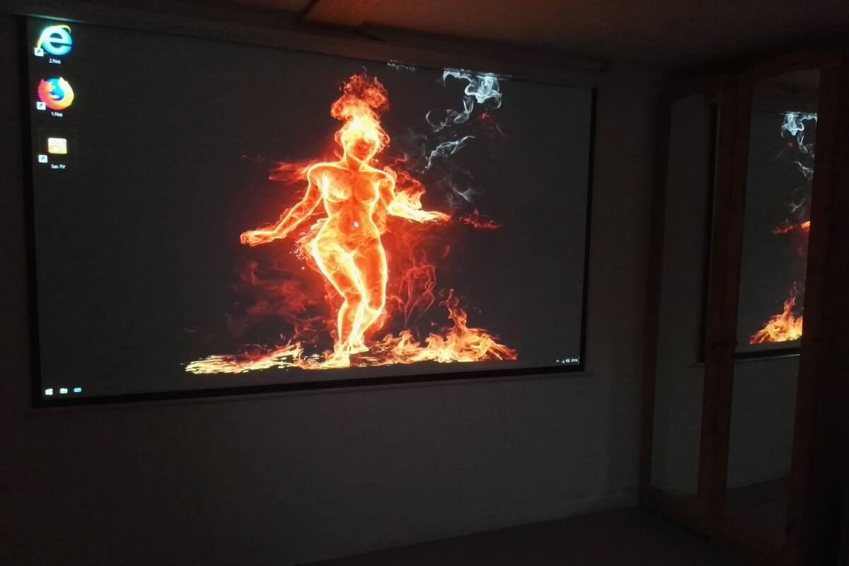 Quarto com uma tela grande exibindo uma imagem flamejante.
