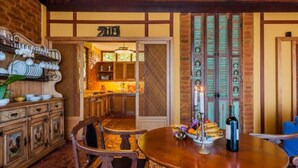 A traditional dining area with wooden furniture, a table set with plates, bowls, and a bottle.