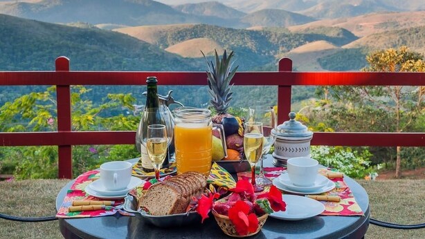 A table set with breakfast items and a scenic mountain view.