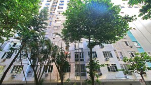 A multi-story building with balconies and air conditioning units, surrounded by trees. - MZ Apartments Leme III (Rio de Janeiro)