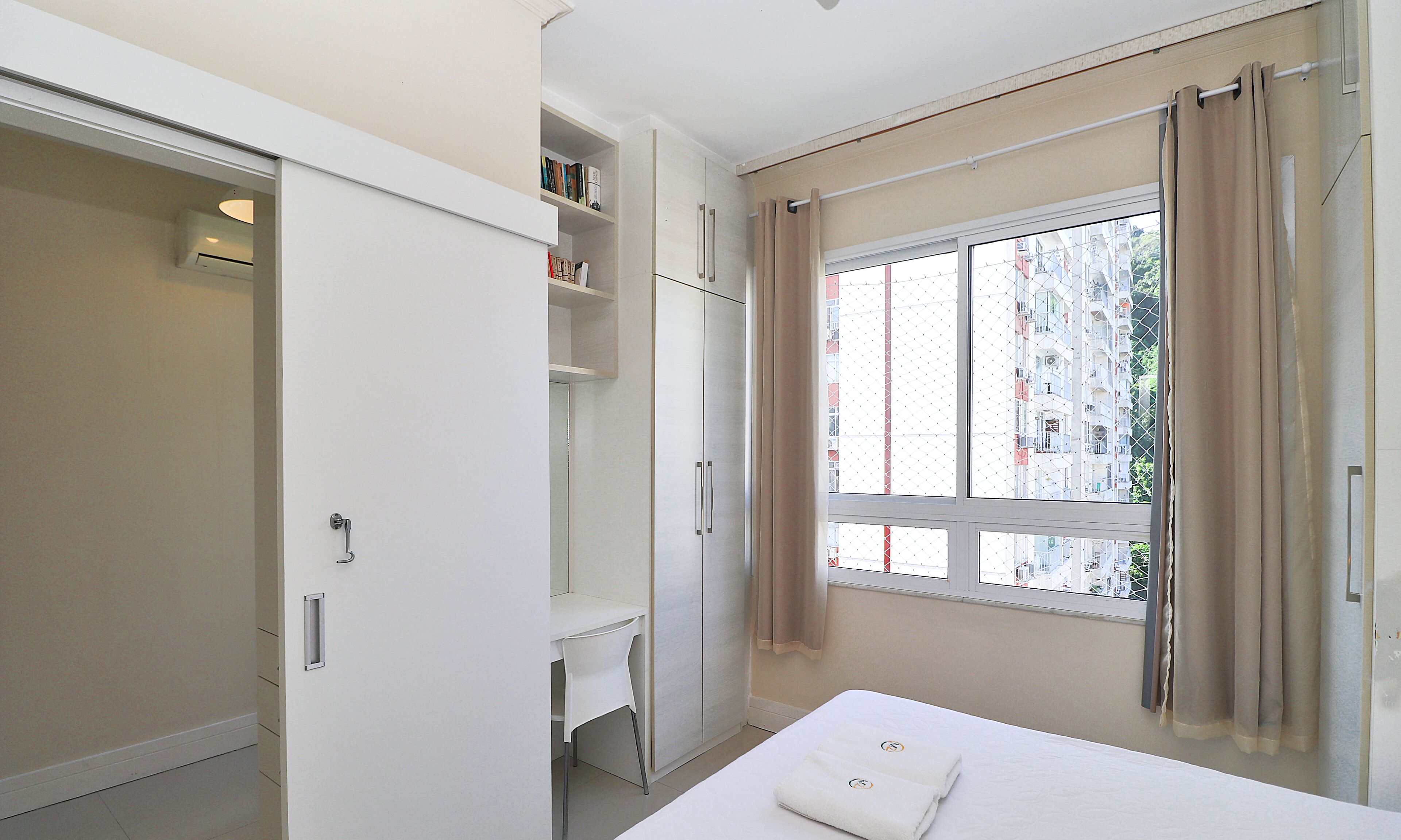 Une chambre d’hôtel avec un lit, un bureau et une armoire.