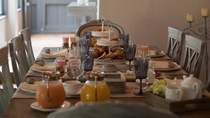 Una mesa de comedor dispuesta con platos, vasos y una araña.