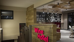 A reception area with a wooden reception desk and a sign that reads "Wine Hotel." - Wine Hotel (Chisinau)