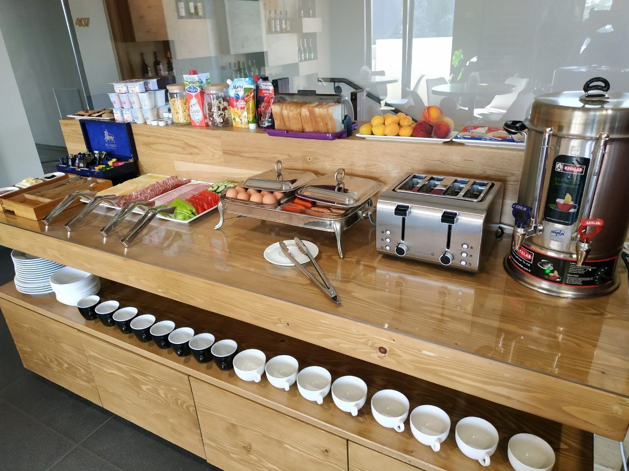 A breakfast buffet with various food items, a coffee machine, and a toaster.