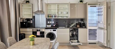 Una cucina moderna con elettrodomestici integrati, una zona pranzo con tavolo e sedie, e vista sulla città.