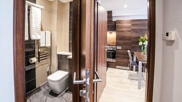 A modern bathroom with a toilet, towel rack, and a shower area.