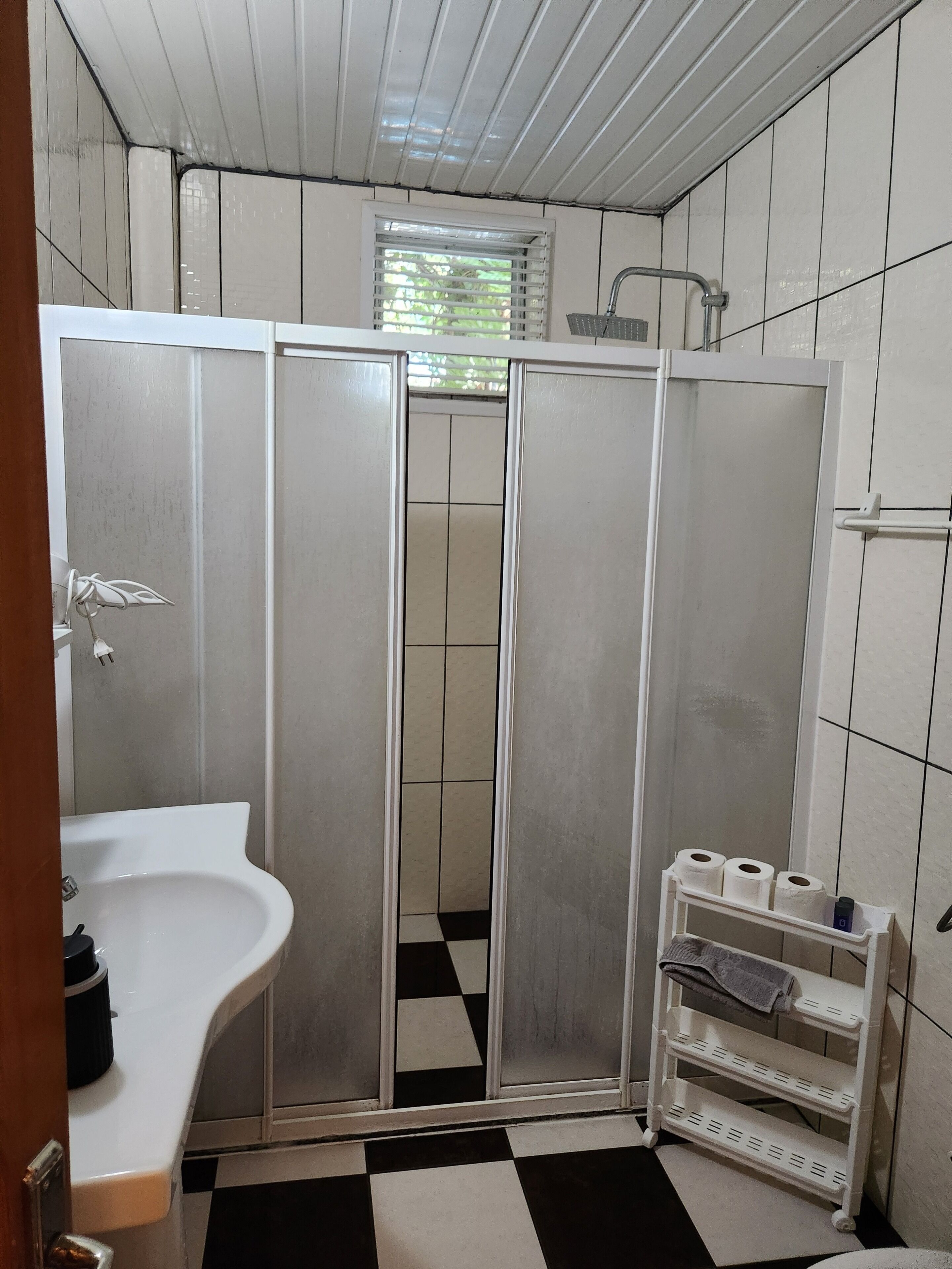 Een douche, een regendouche, een haardroger, pantoffels