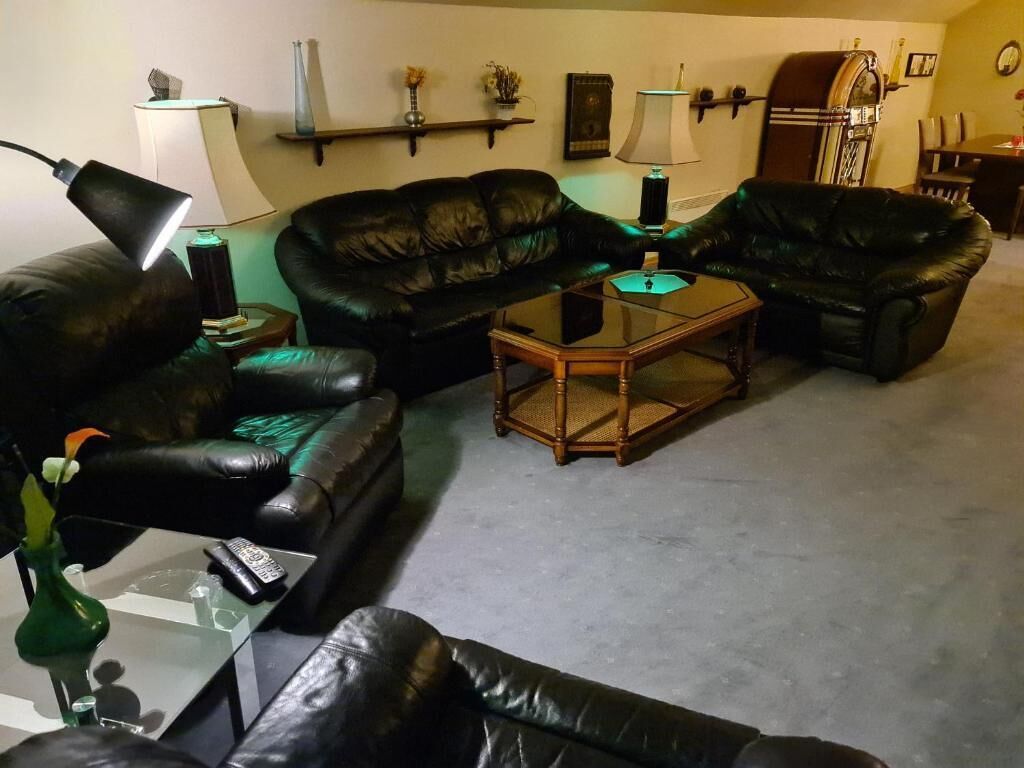 A living room with a sofa set, a coffee table, and a lamp.