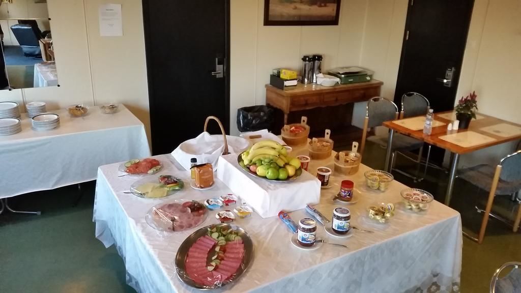 A buffet table with various food items and condiments.