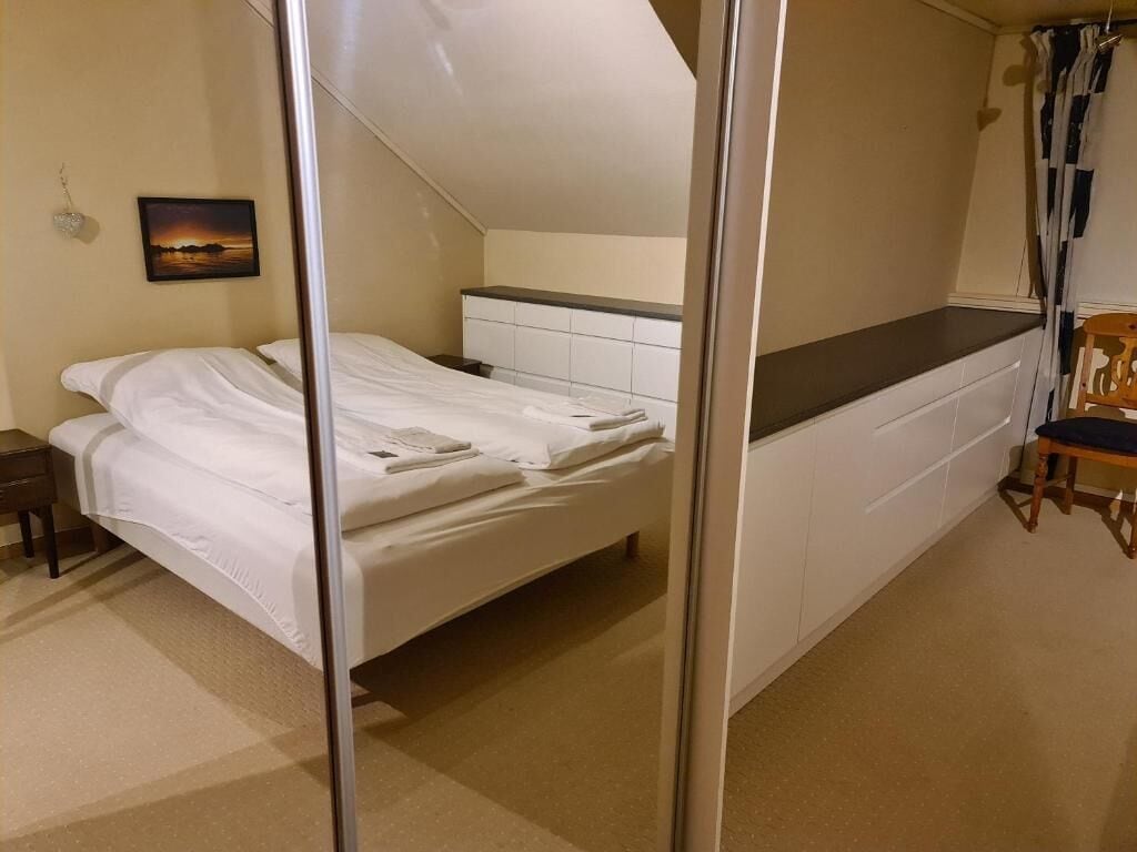 A bedroom with a bed, a nightstand, a dresser, and a chair.