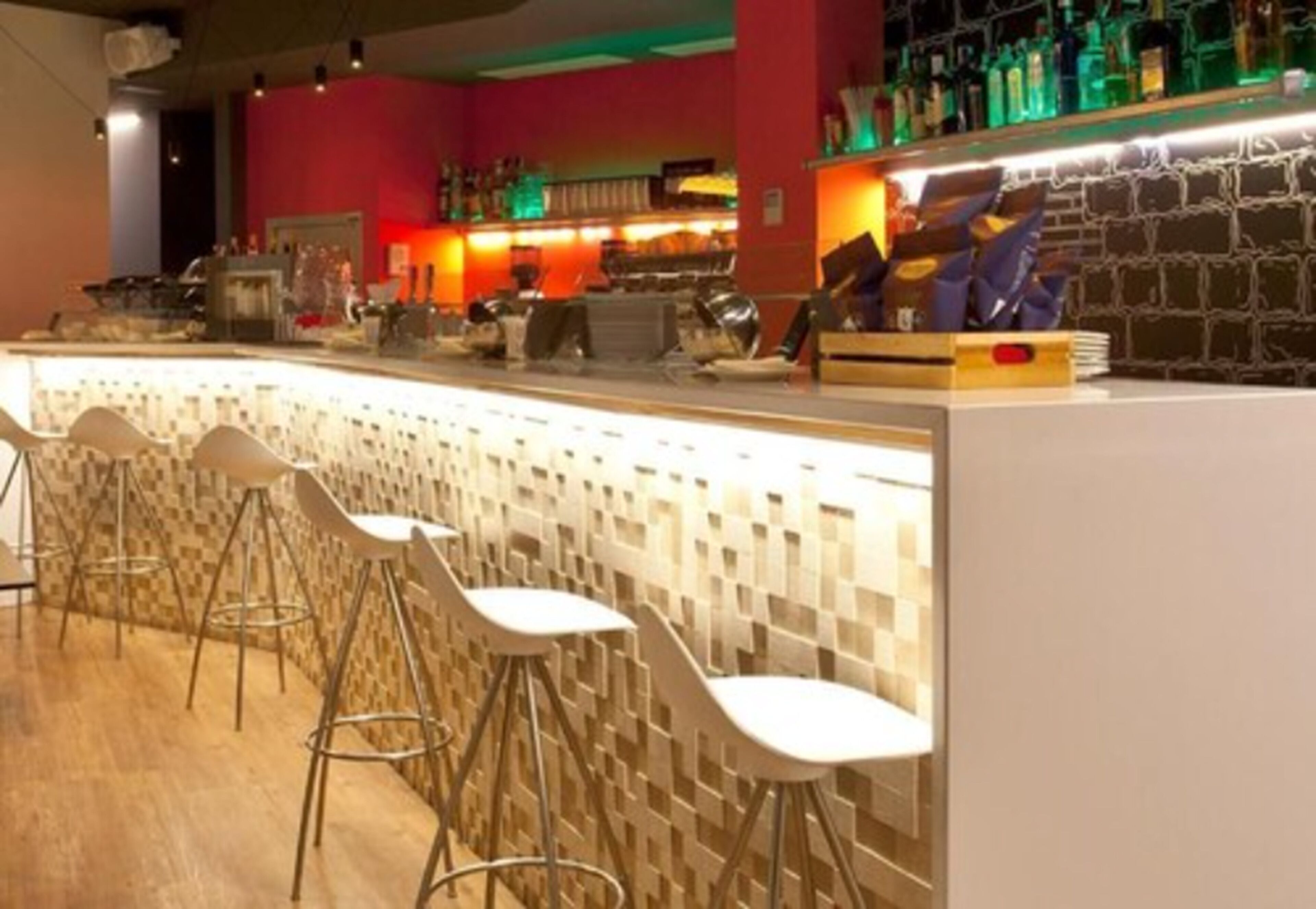 A bar area with a counter, stools, and a brick wall.