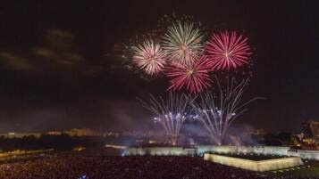 A nighttime outdoor event with fireworks and a large crowd.