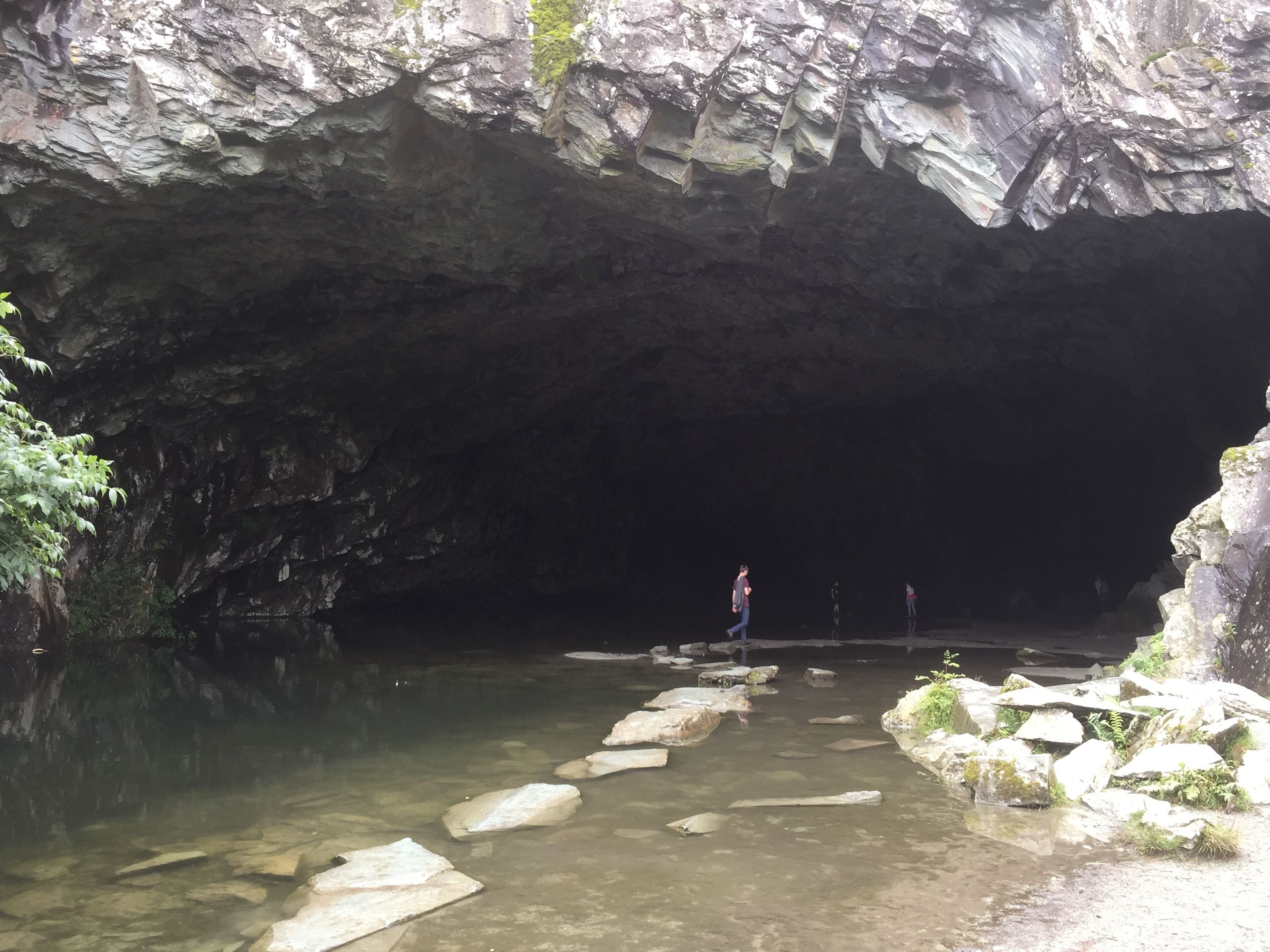 A cave entrance with a clear water path leading inside.
