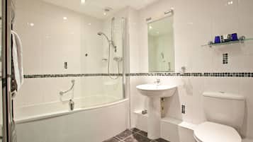 A modern bathroom with a glass-enclosed shower, a white sink, and a toilet.