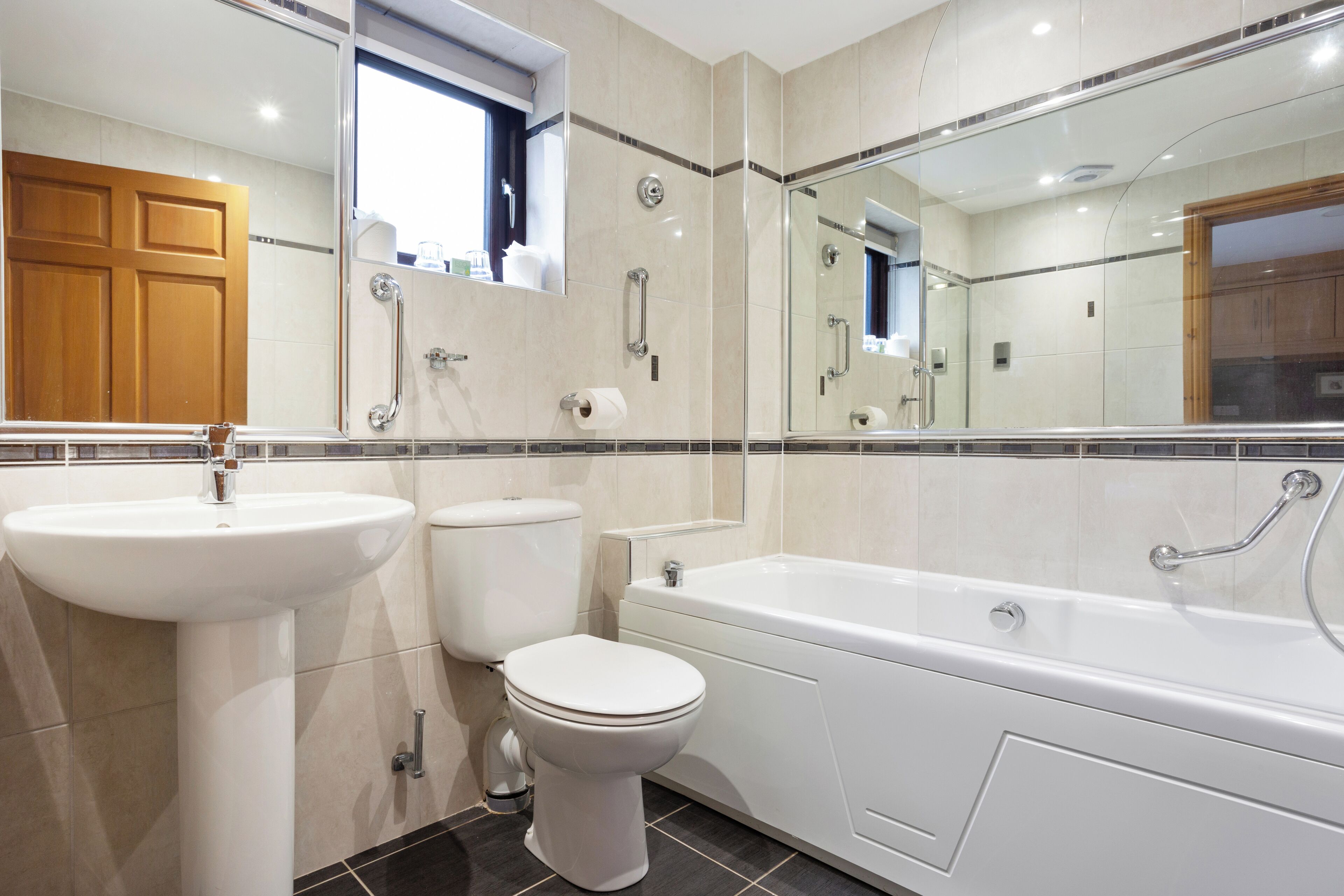 Een moderne badkamer met een wastafel, toilet en bad.