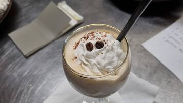 Un postre en un vaso sobre una mesa, con una servilleta debajo.