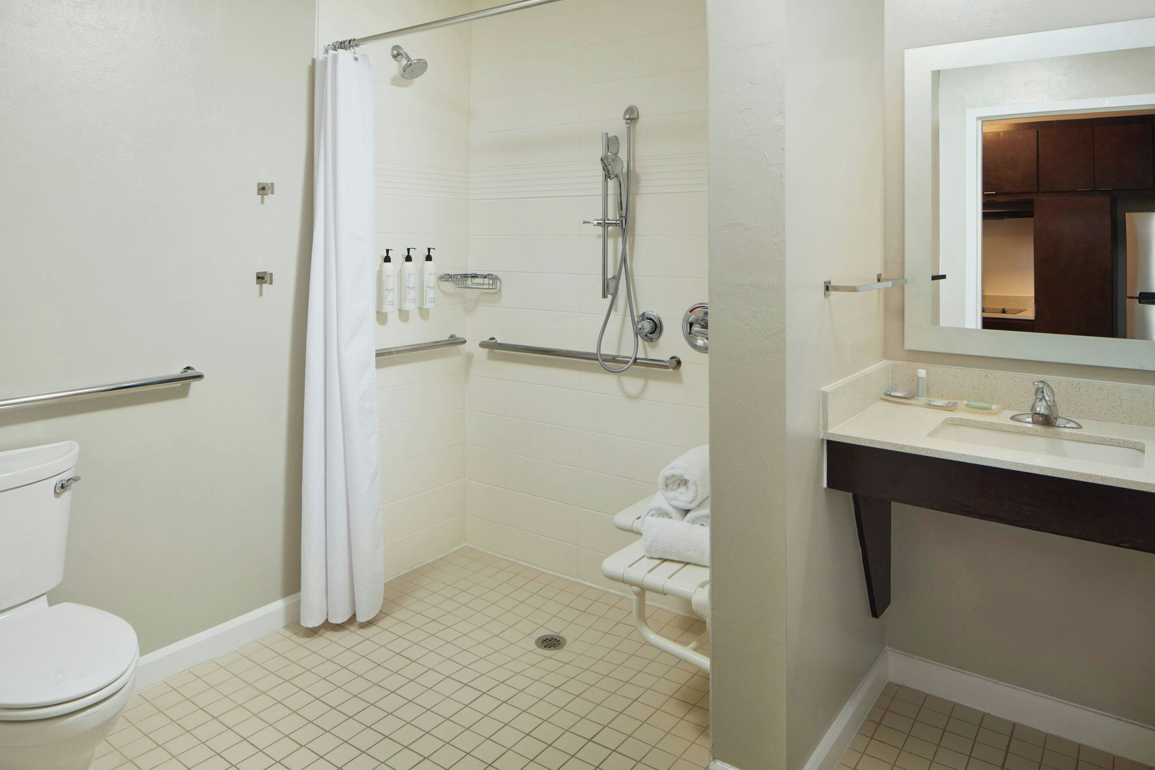 A bathroom with a shower, toilet, and sink.