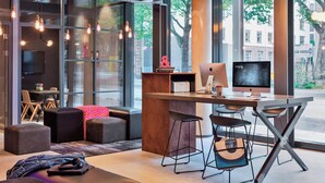 Un espacio de trabajo moderno con una mesa grande, dos monitores y taburetes de bar.
