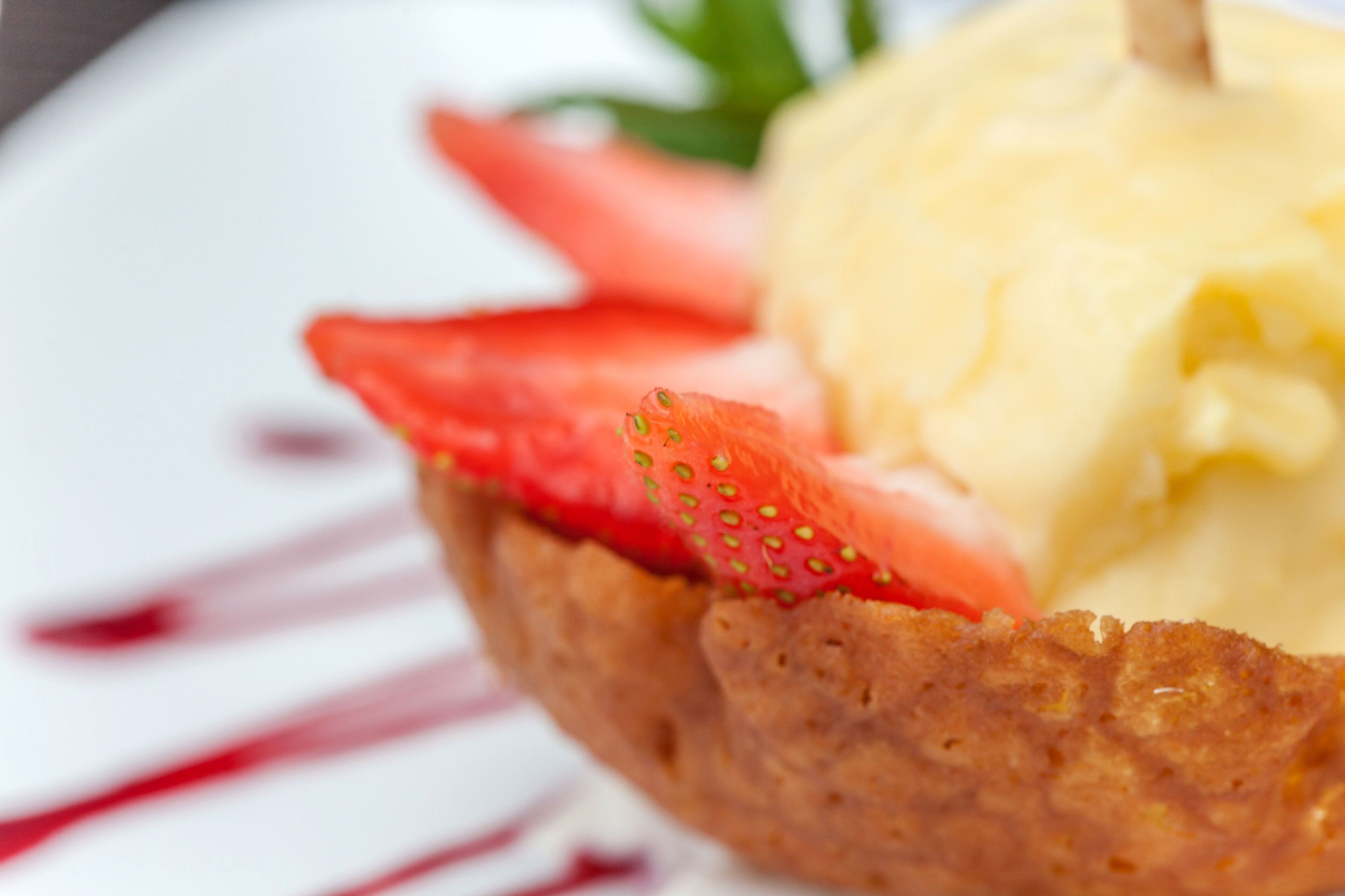 A dessert with strawberries and ice cream on a plate.