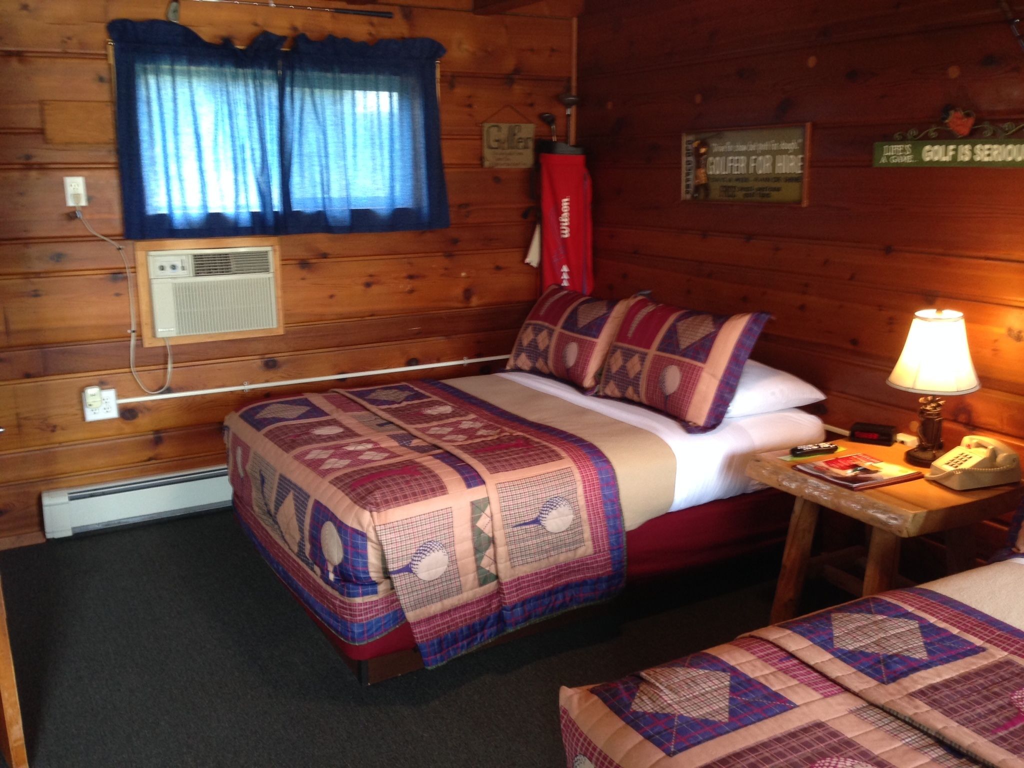Um quarto acolhedor em estilo cabana, com uma cama, uma mesinha de cabeceira, uma luminária e um edredom acolchoado.
