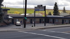 Un motel avec une enseigne indiquant « TallWinds Motel ».