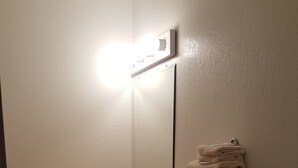 Une salle de bain avec un lavabo, un miroir et des serviettes pliées.