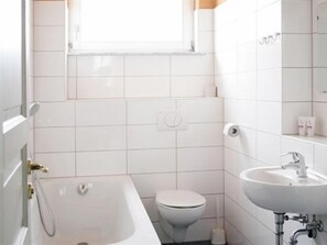 A bathroom with a bathtub, toilet, and sink.