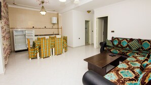 Un salon comprenant un canapé, une table basse et un coin repas avec des chaises et une table.