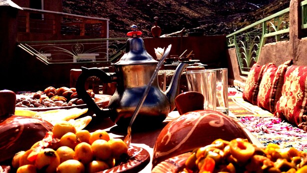Vista de la montaña con una mesa de comida y una olla metálica tradicional.