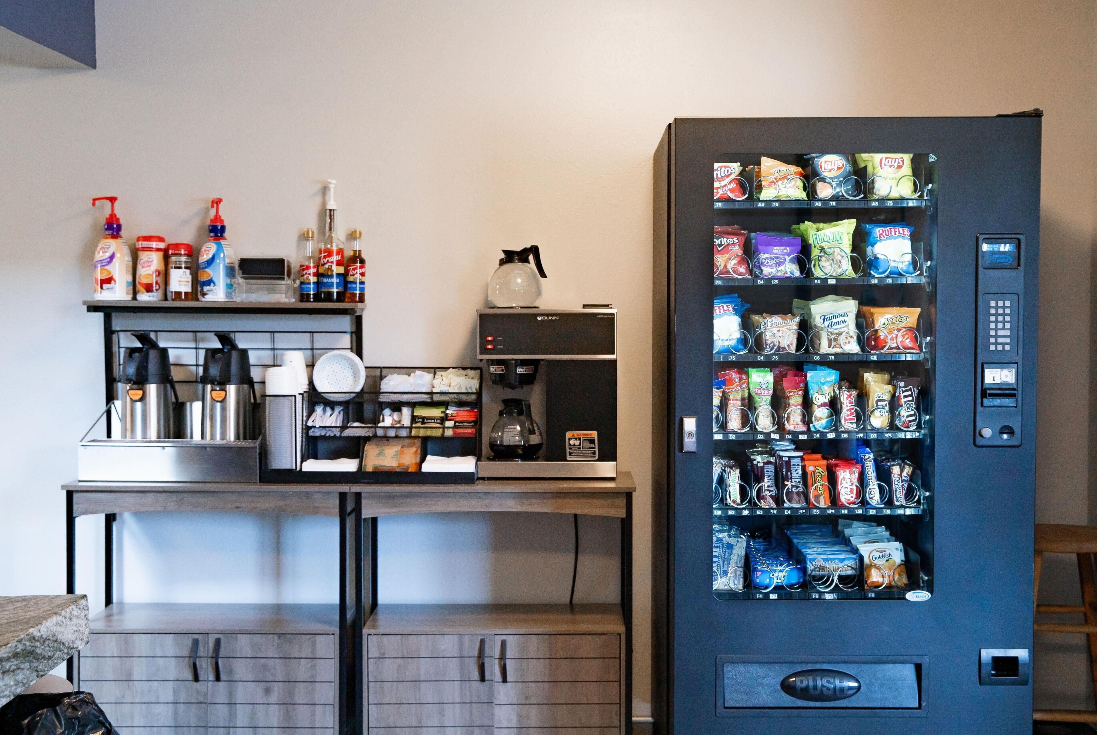 Una kitchenette con cafetera, microondas y un estante con productos de limpieza.