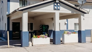 A building with a covered entrance, a satellite dish, and flower planters.