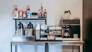 A coffee station with dispensers, a coffee machine, and various coffee-related items on a counter.