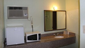 A bathroom with a sink, mirror, and a microwave. - Sportsman Motel (Eagle Lake)