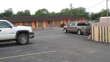 A parking lot with a motel in the background.