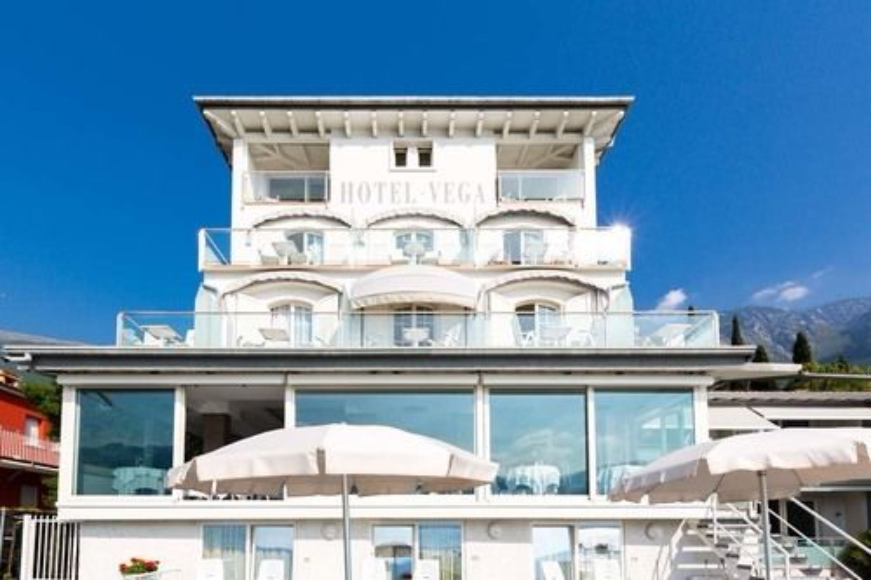 Ein mehrstöckiges Hotel mit Balkonen, großen Fenstern und Außenbereichen zum Sitzen.