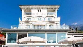 Ein mehrstöckiges Hotel mit Balkonen, großen Fenstern und Außenbereichen zum Sitzen.