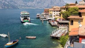 Une ville côtière dotée d’un quai pour les traversiers, de bateaux et d’immeubles avec des balcons donnant sur l’eau.