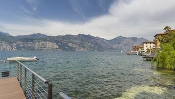 A lake with a wooden dock, boats, and buildings on the shore.