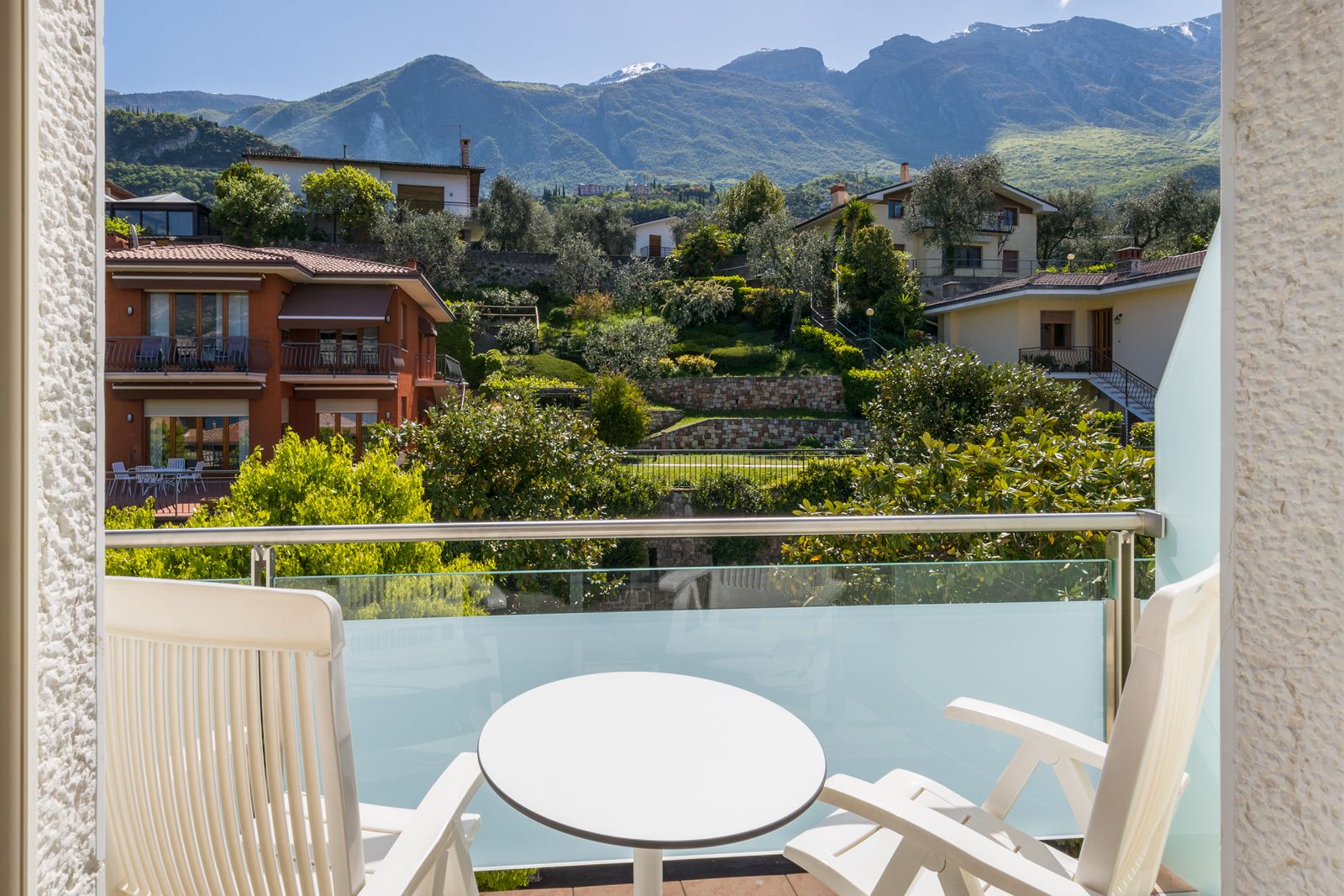 A balcony with a glass railing overlooking a mountainous landscape.
