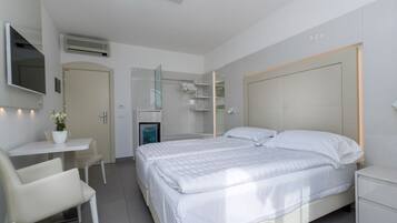Ein modernes Hotelzimmer mit Bett, Nachttischen, einem Schreibtisch und einem Sessel.