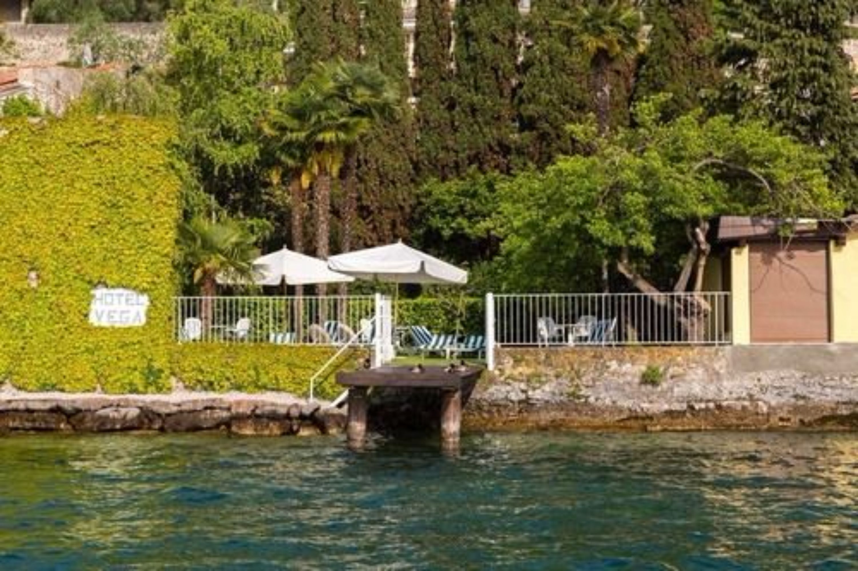 Un hôtel doté d’une piscine, entouré d’une végétation luxuriante et d’une clôture.